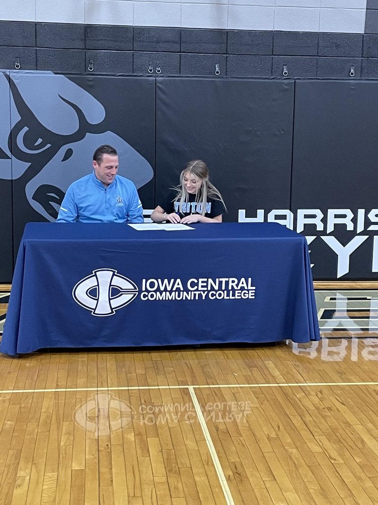 Zoe Etter signing a Letter on Intent for Cheerleading at Iowa Central Community College.  Coach Mitch Murphy is looking on.